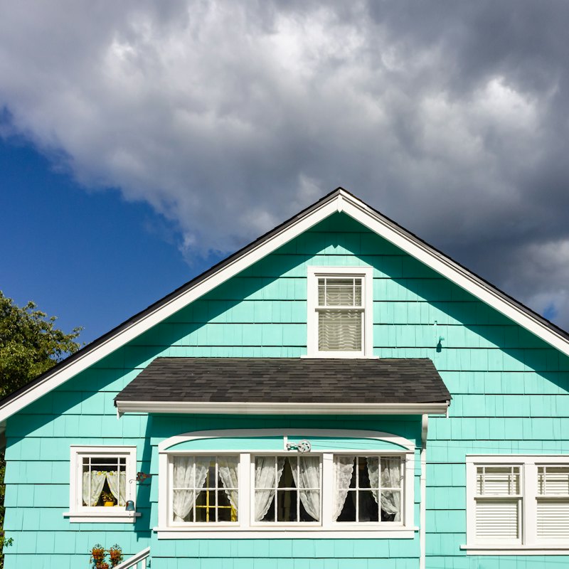 Maison au revêtement bleu avec fenêtres et moulures blanches