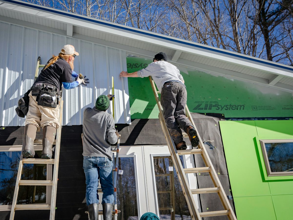 Installateur posant un revêtement extérieur en aluminium horizontal sur une maison à Montréal
